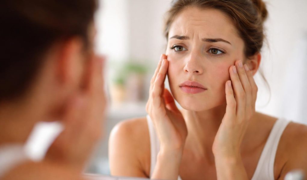personne-examinant-peau-miroir-preoccupation