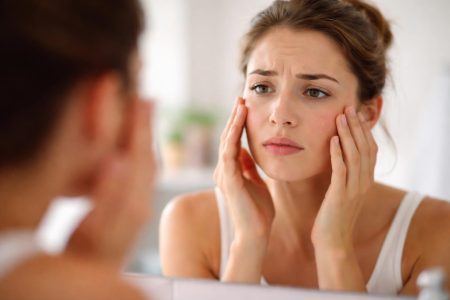 personne-examinant-peau-miroir-preoccupation